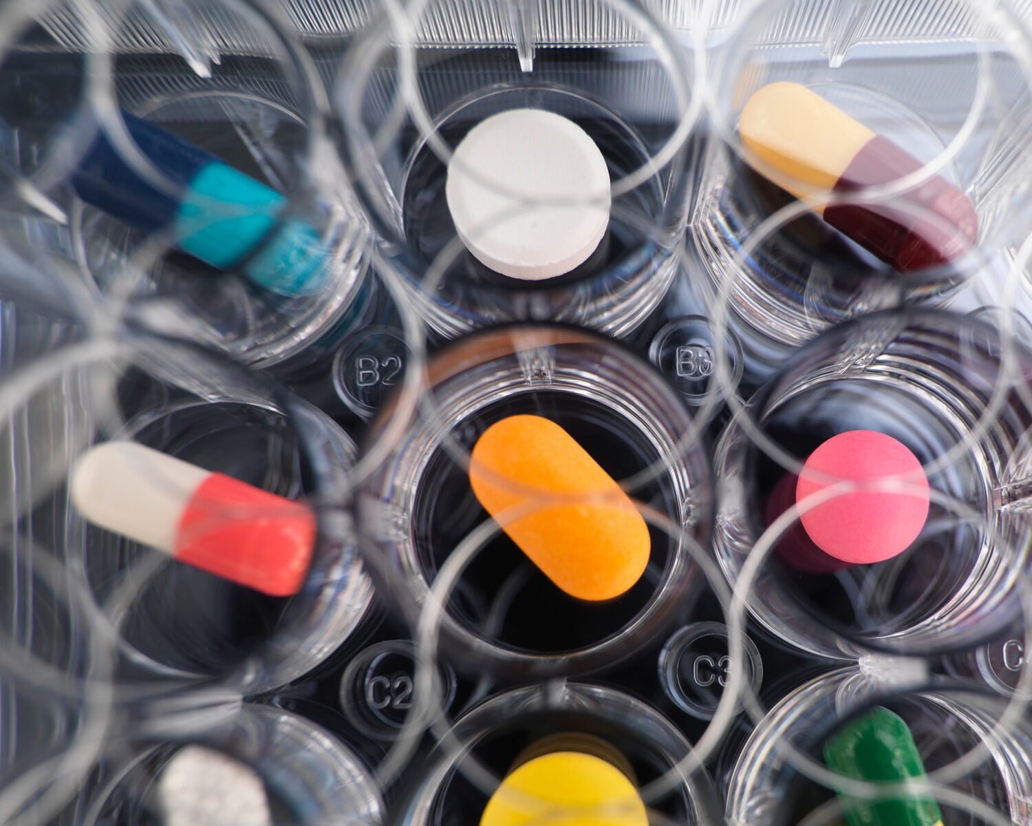 Pharmaceutical research, overhead view of variety of medical drugs in a multi well tray for