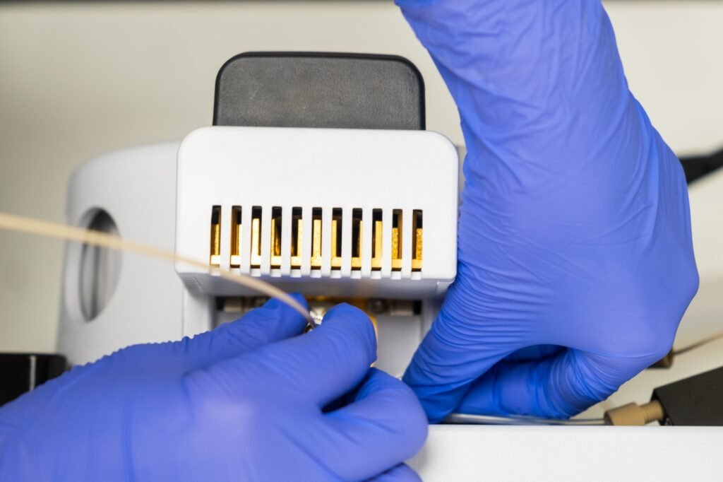 Close up laboratory worker connect a needle to the ion source of the mass spectrometer. Maintenance