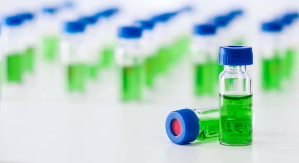 HPLC vials with green sample of plant extracts. Developing of drugs based on natural products