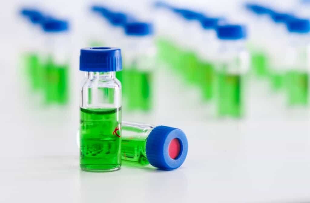 HPLC vials with green sample of plant extracts. Developing of drugs based on natural products