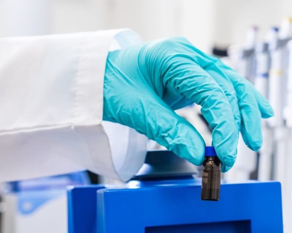 A chemist uses a vortex mixer to shake samples before HPLC analysis.